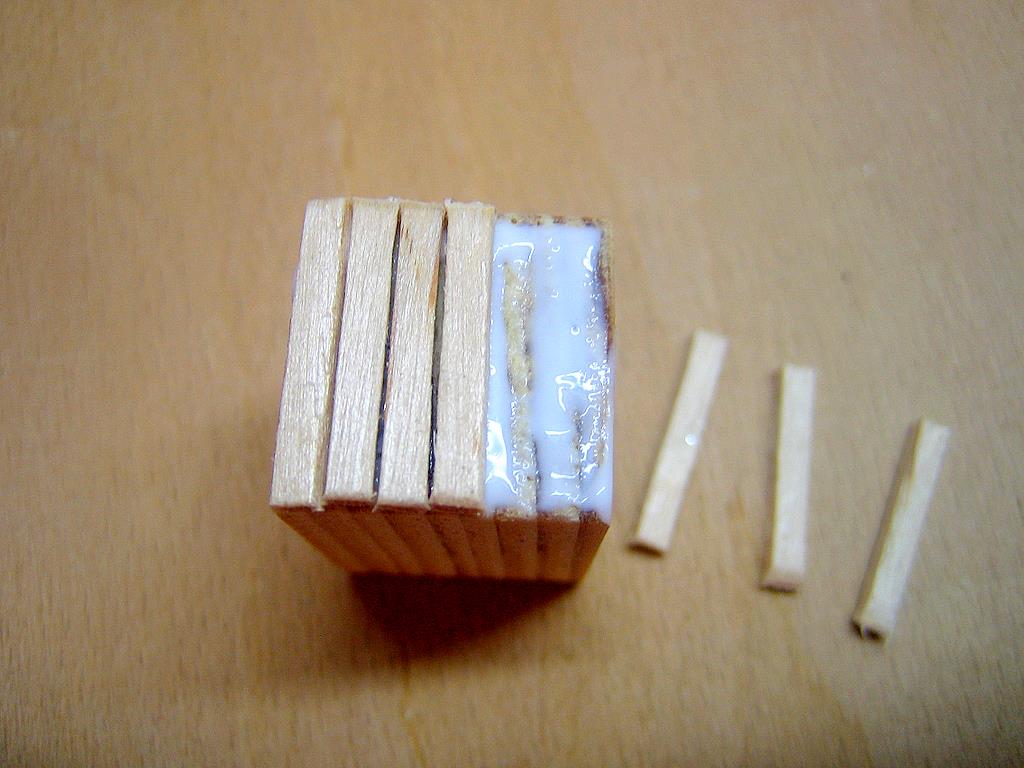 Zuerst Brettchen auf Kistenbreite ablängen (geht gut mit Seitenschneider), dann die beiden Kistenfronten mit den Brettchen bekleben. Kleine Spalten zwischen den Brettern dürfen sein.