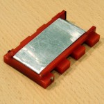 Funktionsstudie Entkuppler zum Einklipsen in gerade Gleise. Die Stromversorgung erfolgt über Metallzapfen, die am Gleis anliegen. Funktionsstudie Entkuppler zum Einklipsen in gerade Gleise. Die Stromversorgung erfolgt über Metallzapfen, die am Gleis anliegen.