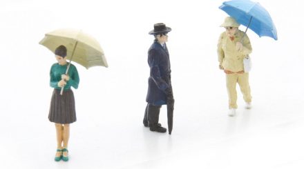 Set mit drei Figuren mit Regenschirm